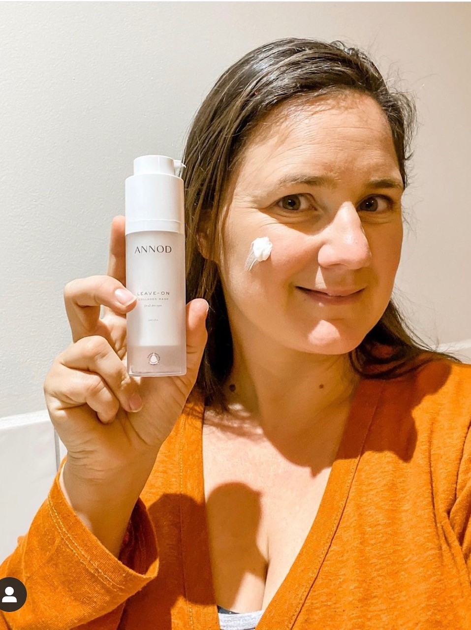 Our customer Kristie holding the bottle of Leave-On Collagen Mask
