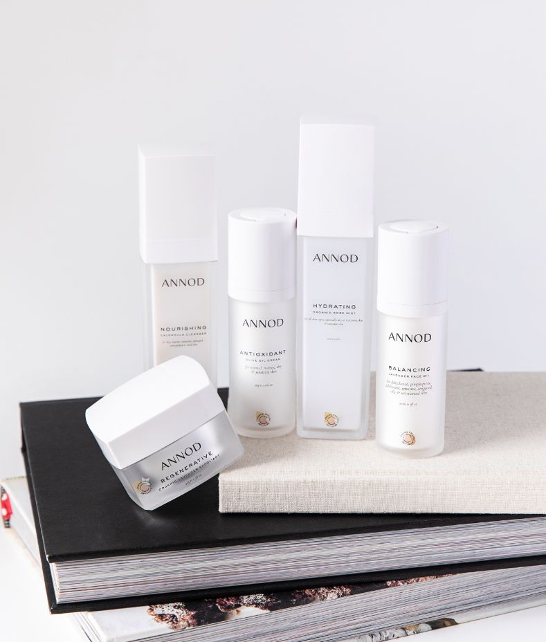 Annod Simplicity Club natural skincare products styled on a stack of books